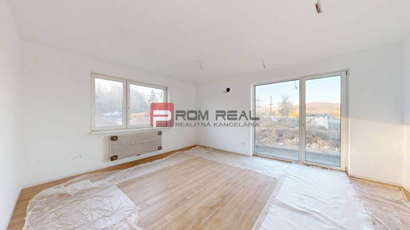 Ein Zimmer mit Holzboden und großen Fenstern bietet Helligkeit in einer 2-Zimmer-Wohnung.