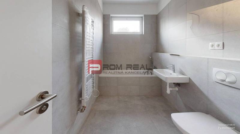 Badezimmer in einer 2-Zimmer-Wohnung mit Waschbecken, Toilette und Fenster für natürliches Licht.