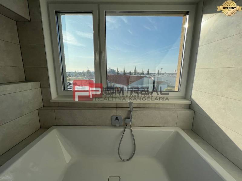 Badezimmer mit Badewanne und Fenster in einer 4-Zimmer-Wohnung.