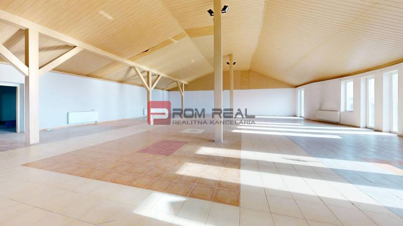Geräumiges Interieur eines Gebäudes mit gemustertem Boden und Holzdecke.