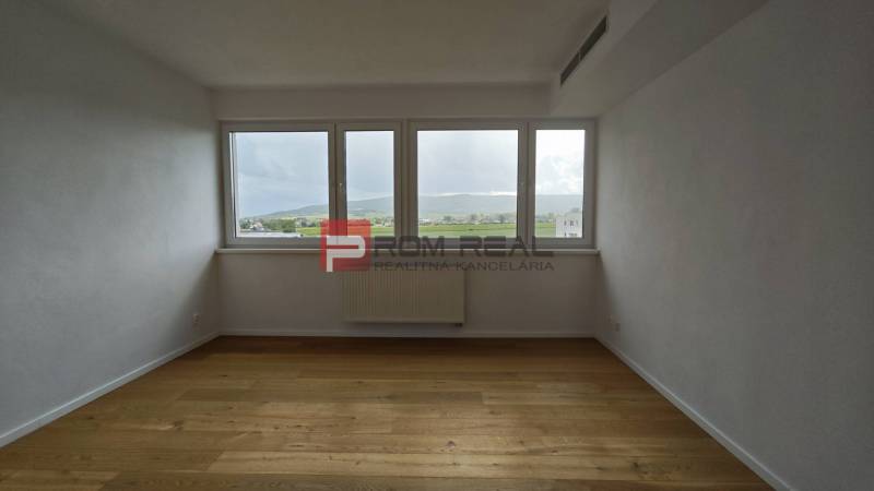 Ein geräumiges Zimmer mit hellen Wänden und Holzboden in einer 4-Zimmer-Wohnung.