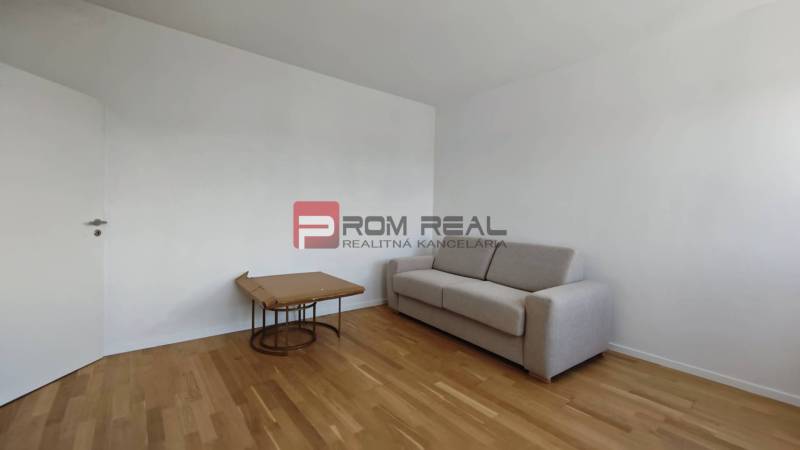 Ein Zimmer in einer 4-Zimmer-Wohnung mit einem Sofa und einem Tisch auf einem Holzboden.