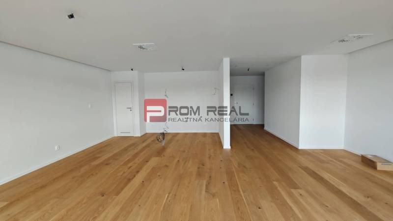 Ein geräumiges Zimmer mit Holzboden in einer 4-Zimmer-Wohnung, bereit zur Einrichtung.