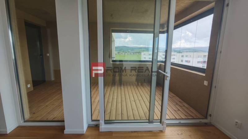 Glastüren führen auf die Loggia in einer 4-Zimmer-Wohnung mit Blick auf die Hügel.