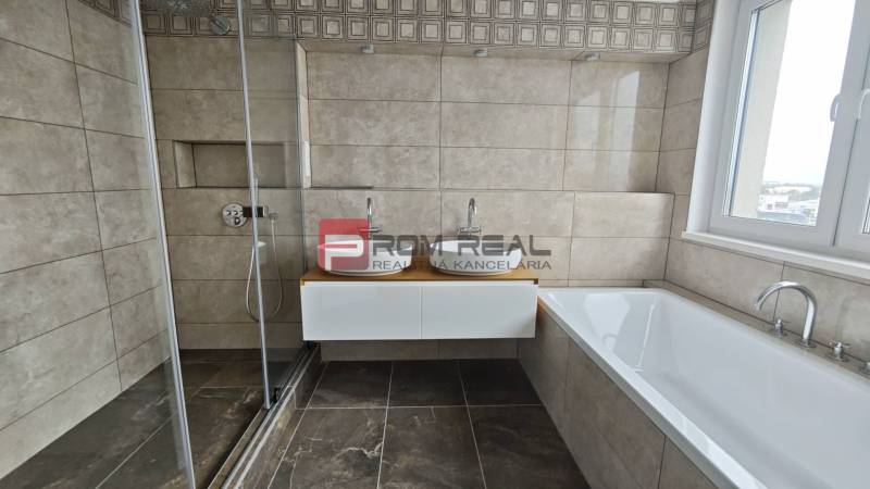 Ein Badezimmer in einer 4-Zimmer-Wohnung mit einer Dusche, einer Badewanne und einem Doppelwaschbecken.