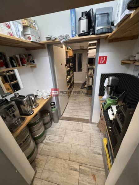 Lagerraum mit Regalen, Fässern und Kaffeemaschinen in Geschäftsräumen.