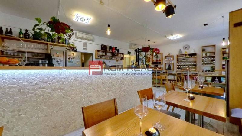 Innenraum von Geschäftsräumen mit Holztischen und Bar, dekorativen Elementen und Regalen.