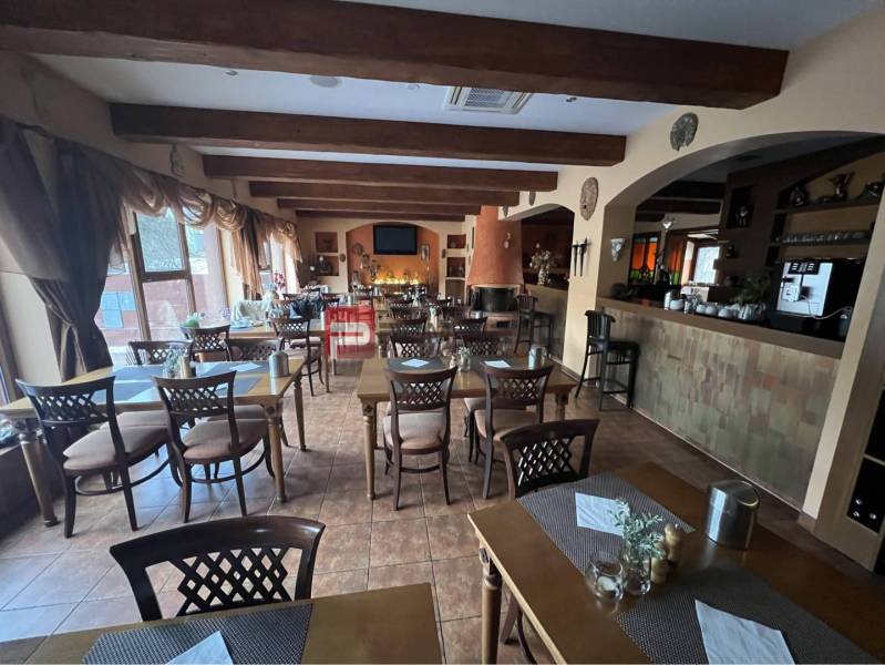 Restaurant im Hotelbereich mit Holzbalken, Tischen und Stühlen. Hotels und Pensionen.