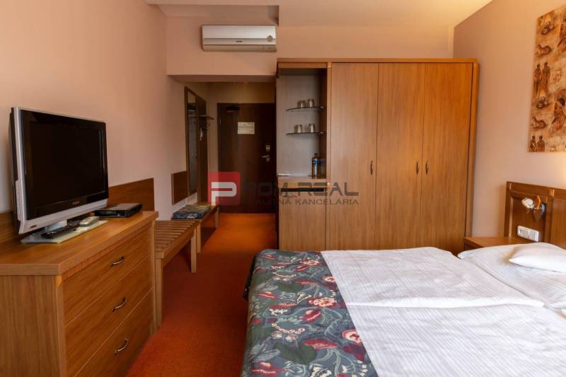 Ein Zimmer im Hotel und in Pensionen mit Fernseher, Schrank und Doppelbett.