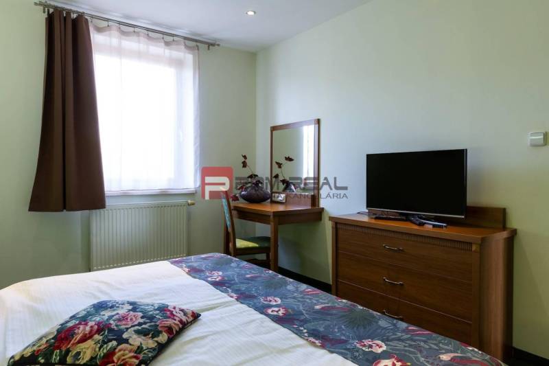 Izba s posteľou, stolíkom a televíziou v Hotely a penzióny.

Zimmer mit Bett, Tisch und Fernseher in Hotels und Pensionen.