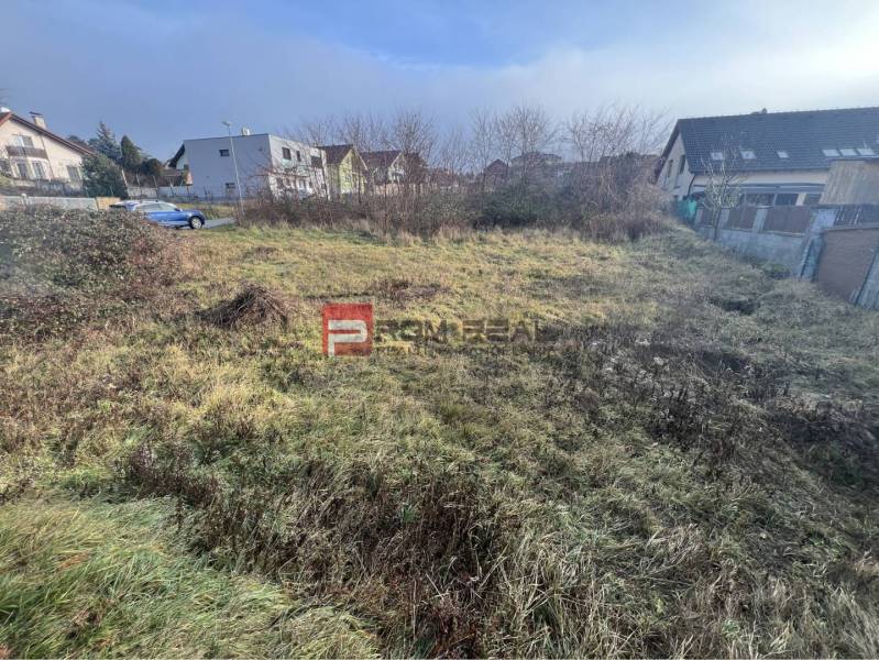 Stupava, Bazová: Grundstücke - Wohnen mit überwachsenem Gras und umliegenden Häusern.