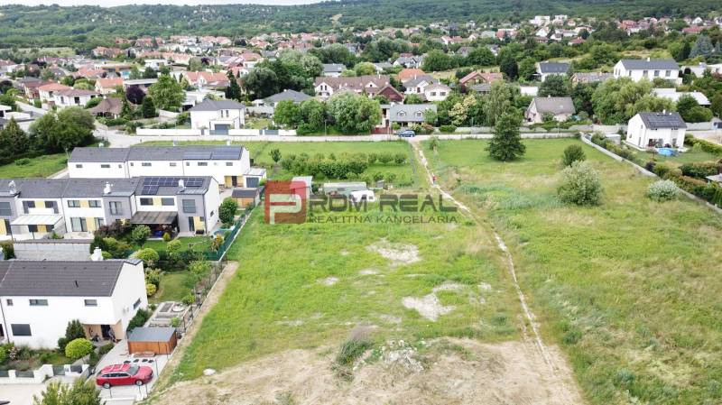 Grundstücke zum Wohnen in Marianka in der Straße Na Ovsisku, umgeben von grünen Gärten und Häusern.