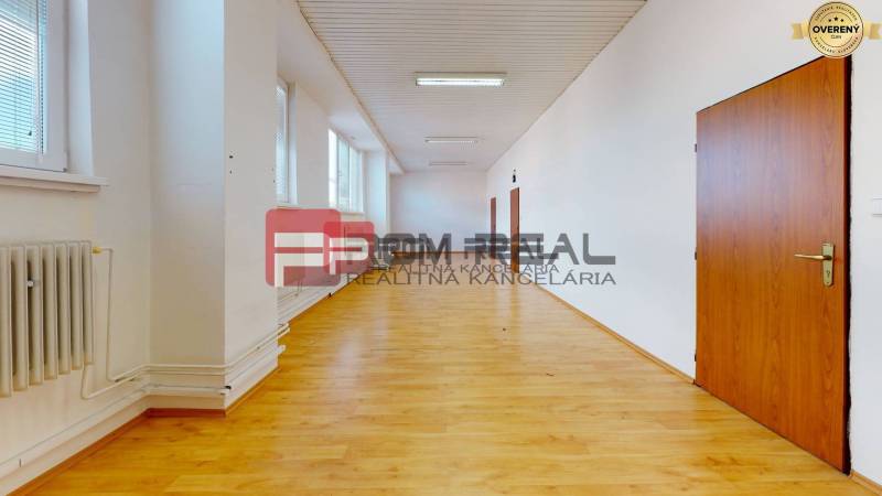 Geräumiger Flur mit Holzboden und Türen in Lager- und Hallenbereichen.