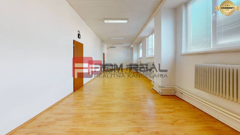 Ein geräumiger, heller Raum mit Holzboden, Heizkörpern und Fenstern in Lagerhäusern und Hallen.