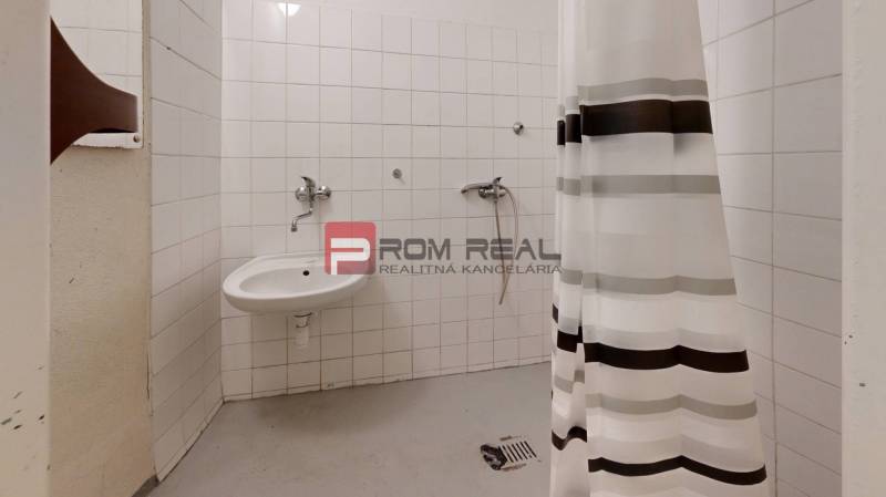 Badezimmer mit Dusche und Waschbecken in den Räumlichkeiten von Lager und Hallen.