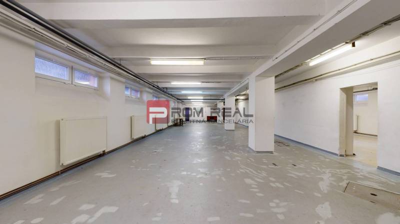 Innenraum mit Beleuchtung und weißen Wänden, geeignet für Lager und Hallen.