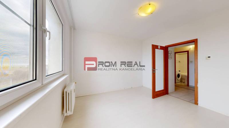 Ein helles Zimmer in einer 4-Zimmer-Wohnung mit großen Fenstern und eingebauter Beleuchtung.