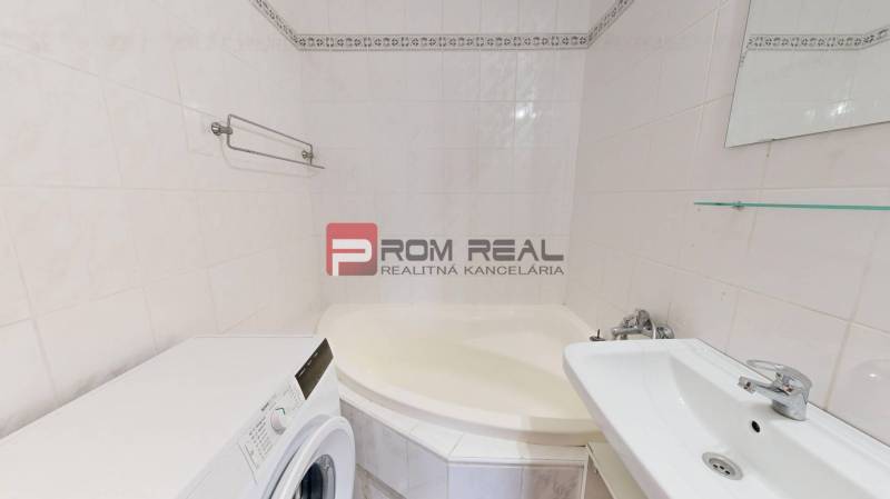 Badezimmer mit Dusche, Waschmaschine und Waschbecken in einer 4-Zimmer-Wohnung.