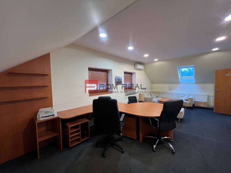Büro von Produktionsräumen mit Stühlen und Tisch, beleuchtet mit künstlichem Licht.