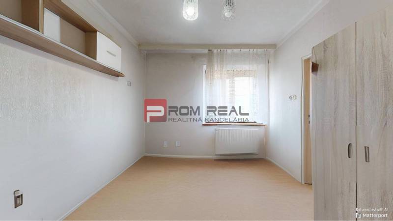 Ein Zimmer mit Regal und Schrank in einem Einfamilienhaus, sanfte Farbtöne, ein Raum mit Fenster.