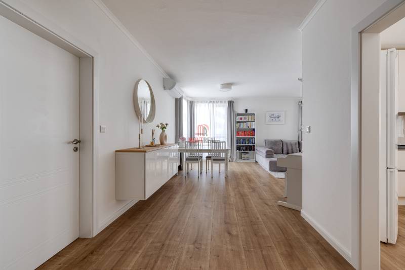 Innenraum einer 3-Zimmer-Wohnung mit Holzboden, Esstisch und Wohnzimmer.