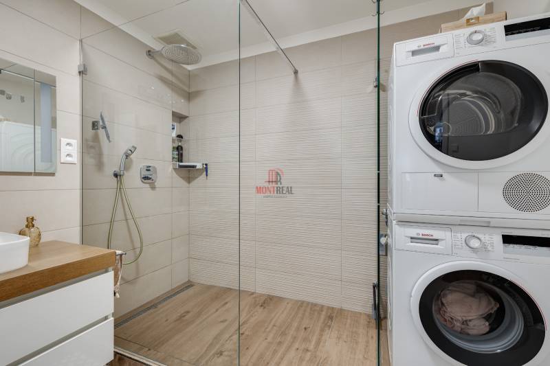 Badezimmer mit Dusche und Waschmaschine in einer 3-Zimmer-Wohnung.