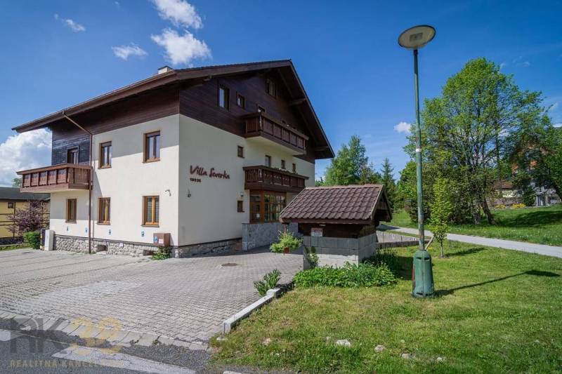 Ferienwohnung in der Hohen Tatra mit Parkplatz, Rasenfläche und sonnigem Wetter.