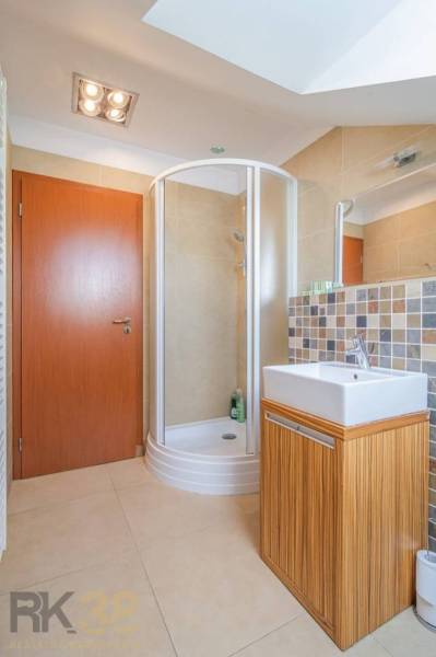Badezimmer in der Ferienwohnung mit Duschkabine und quadratischem Waschbecken.