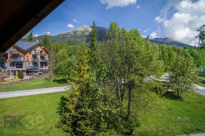 Blick aus einer Ferienwohnung in der Hohen Tatra, mit Bergen und grünen Bäumen.