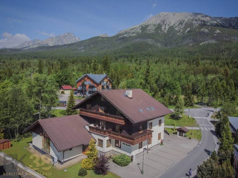 Ferienwohnungen in der Hohen Tatra, umgeben von dichtem Wald und majestätischen Bergen.
