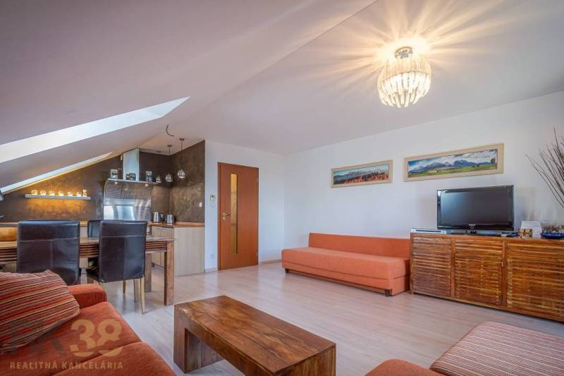 Wohnzimmer der Ferienwohnung mit Sofas, Esstisch und Fernseher.
