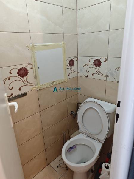 Toilette mit Fliesen und Blumenmuster in einer 2-Zimmer-Wohnung.