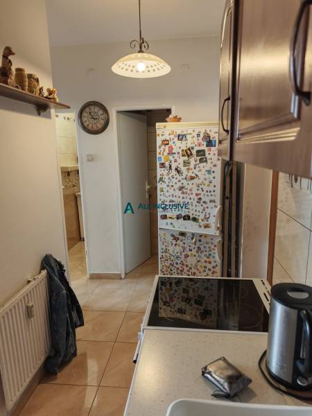Küche in einer 2-Zimmer-Wohnung mit einem Kühlschrank voller Magneten und einem Keramikkochfeld.