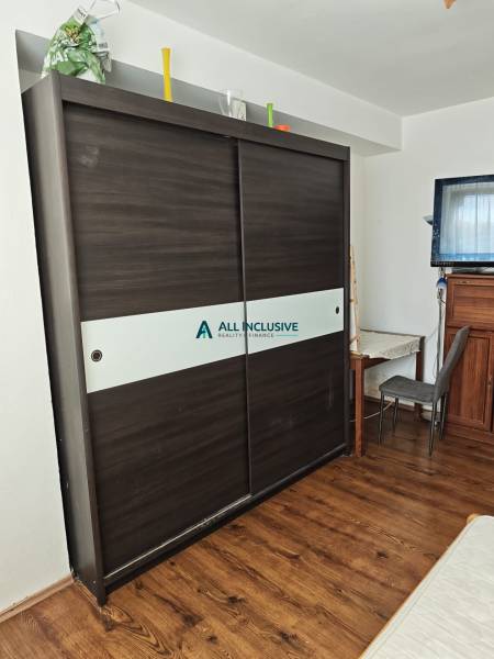 Ein Schrank mit Schiebetüren und ein Schreibtisch in einer 2-Zimmer-Wohnung.