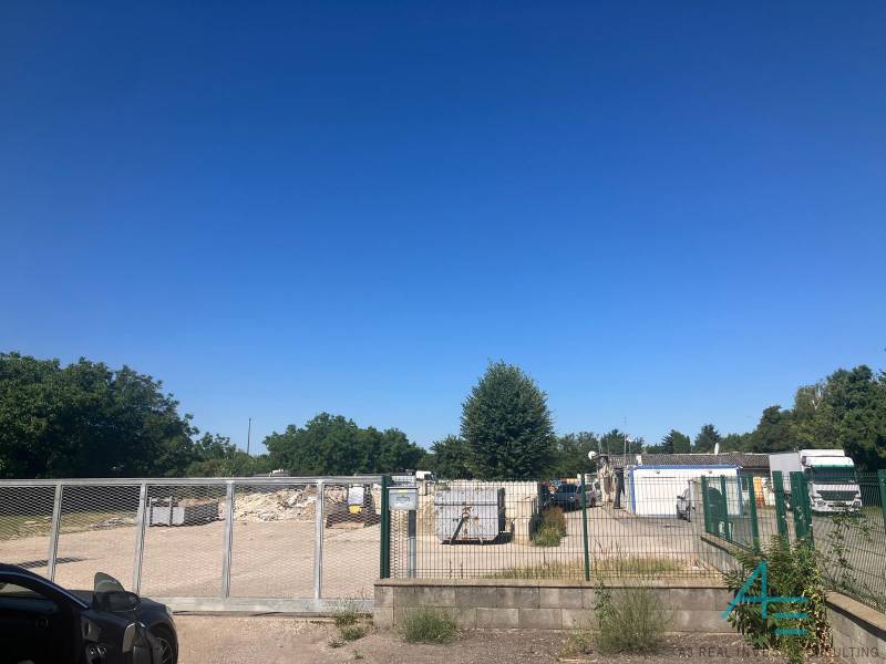 Grundstücke - Gewerbeimmobilien in der Popradská Straße in Bratislava - Podunajské Biskupice mit Tor und Containern.