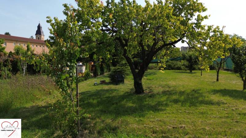 Grünflächen, Bäume und ein Gebäude im Hintergrund in Dolný Bar, Grundstücke - Wohnen.