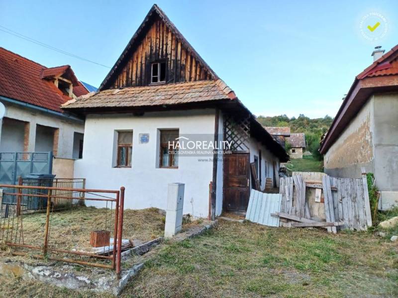 Ein Einfamilienhaus in Ladzany mit einem Schrägdach und einem Garten, umgeben von weiteren Gebäuden.