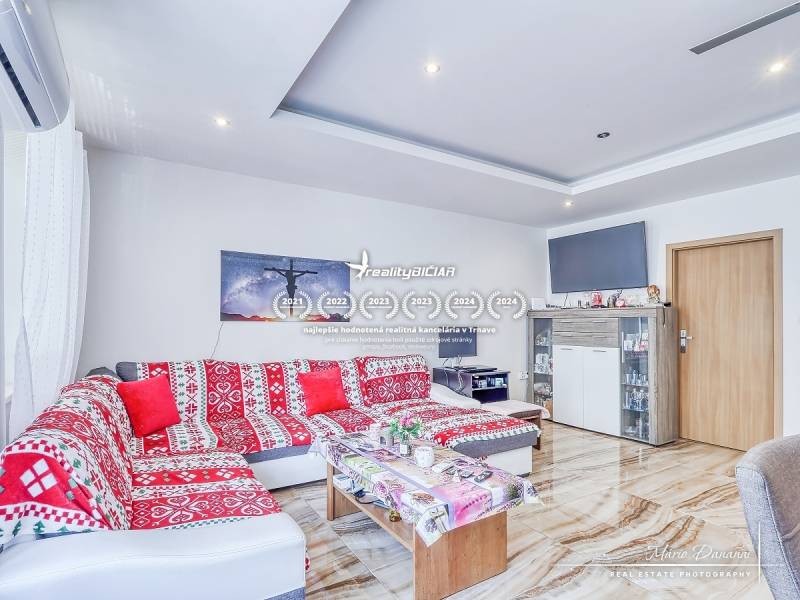Wohnzimmer in einer 2-Zimmer-Wohnung mit einem bunten Sofa und einem Fernseher, hellem Interieur.