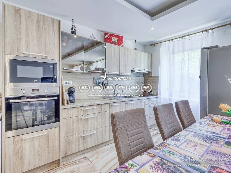 Küche in einer 2-Zimmer-Wohnung mit Holzschränken und eingebauten Geräten.