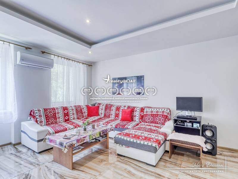 Wohnzimmer mit rotem Sofa und Tisch, 2-Zimmer-Wohnung, Klimaanlage.