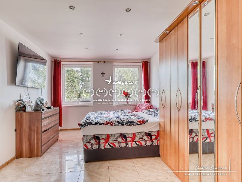 Schlafzimmer mit großem Schrank und Fernseher in einer 2-Zimmer-Wohnung.