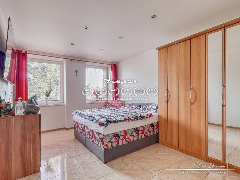 Schlafzimmer in einer 2-Zimmer-Wohnung mit Bett, Kleiderschrank und Fernseher an der Wand.