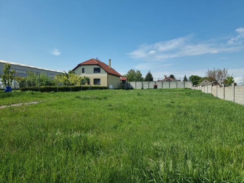 Grundstücke - Wohnen in Cabaj-Čápor mit Rasenfläche und Haus im Hintergrund.