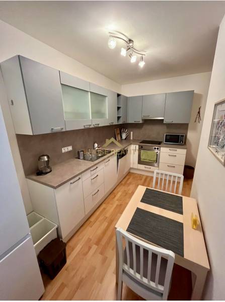 Küche in einer 2-Zimmer-Wohnung mit Holzboden und modernen Geräten.