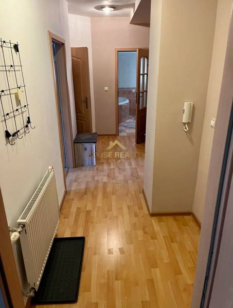 Flur in einer 2-Zimmer-Wohnung mit Holzboden, Garderobe, Eingang zum Badezimmer.