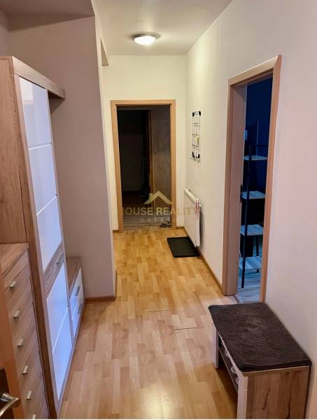 Der Flur in der 2-Zimmer-Wohnung mit hellen Holzmöbeln und offenen Türen.