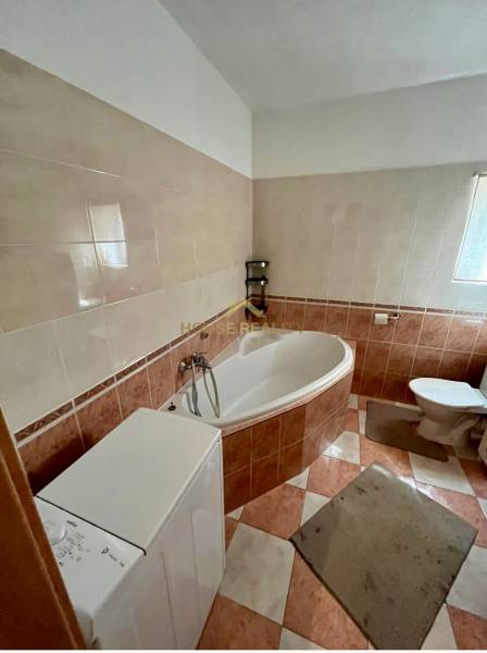 Badezimmer in einer 2-Zimmer-Wohnung mit Badewanne, Waschmaschine und Toilette.