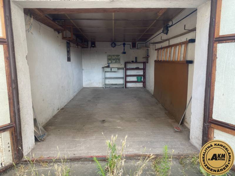 Leere Garage in Zvolen mit Regalen und Werkzeugen an der Wand.