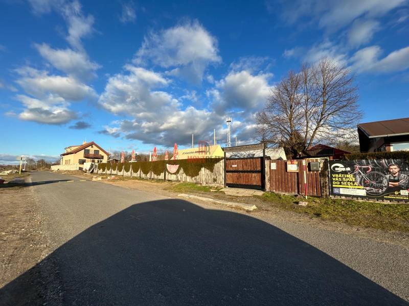 Straße Devinske jazero in Bratislava, Gastronomiebereiche umgeben von einem Zaun und Werbebannern.