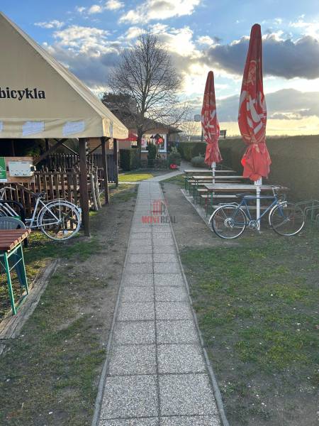 Gehweg neben Gastronomiebereichen mit Fahrrädern und Sonnenschirmen, Devínska Nová Ves, Devínske jazero.